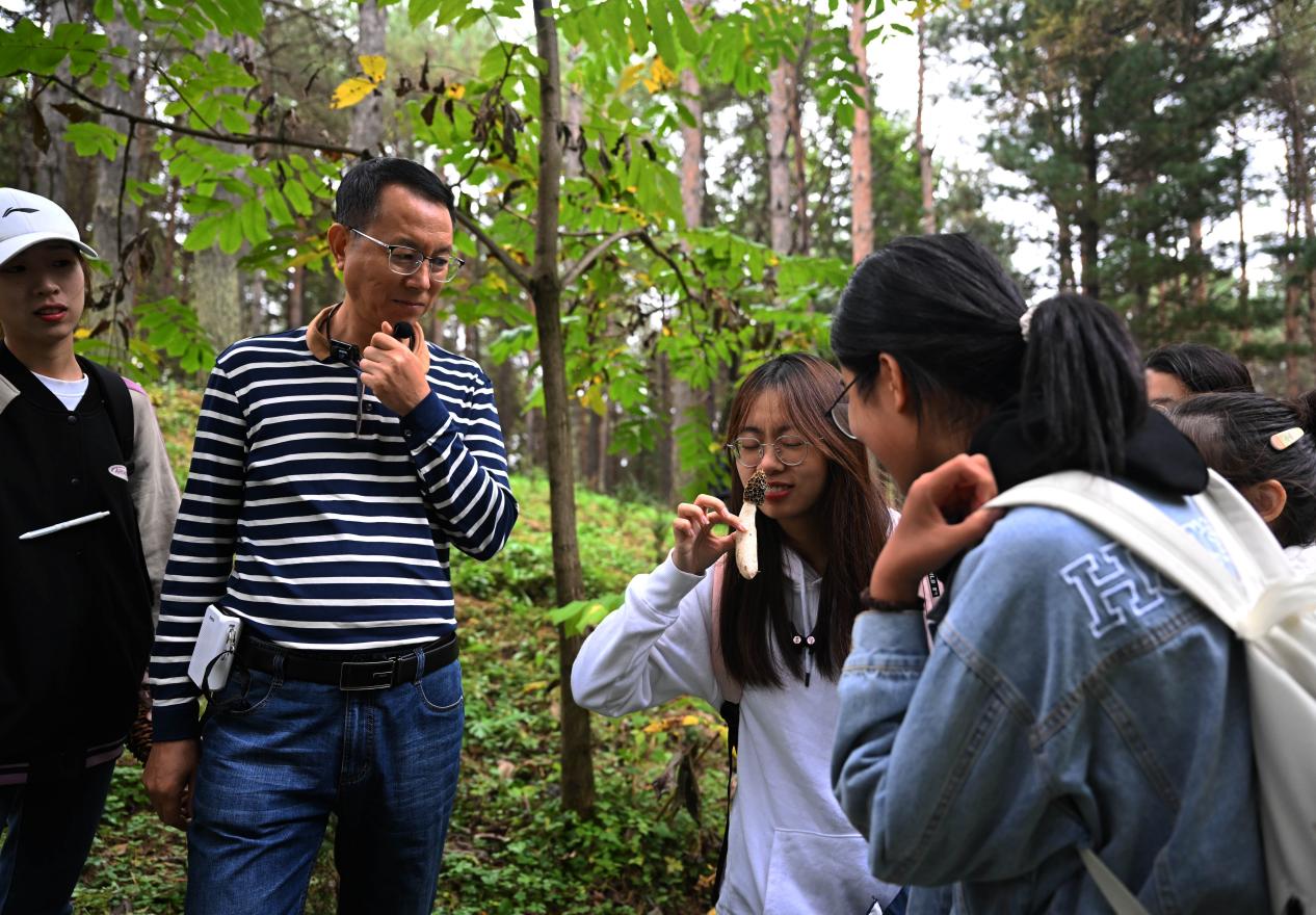 王占斌老師給同學們講解辨識蘑菇。（學校供圖）.jpg