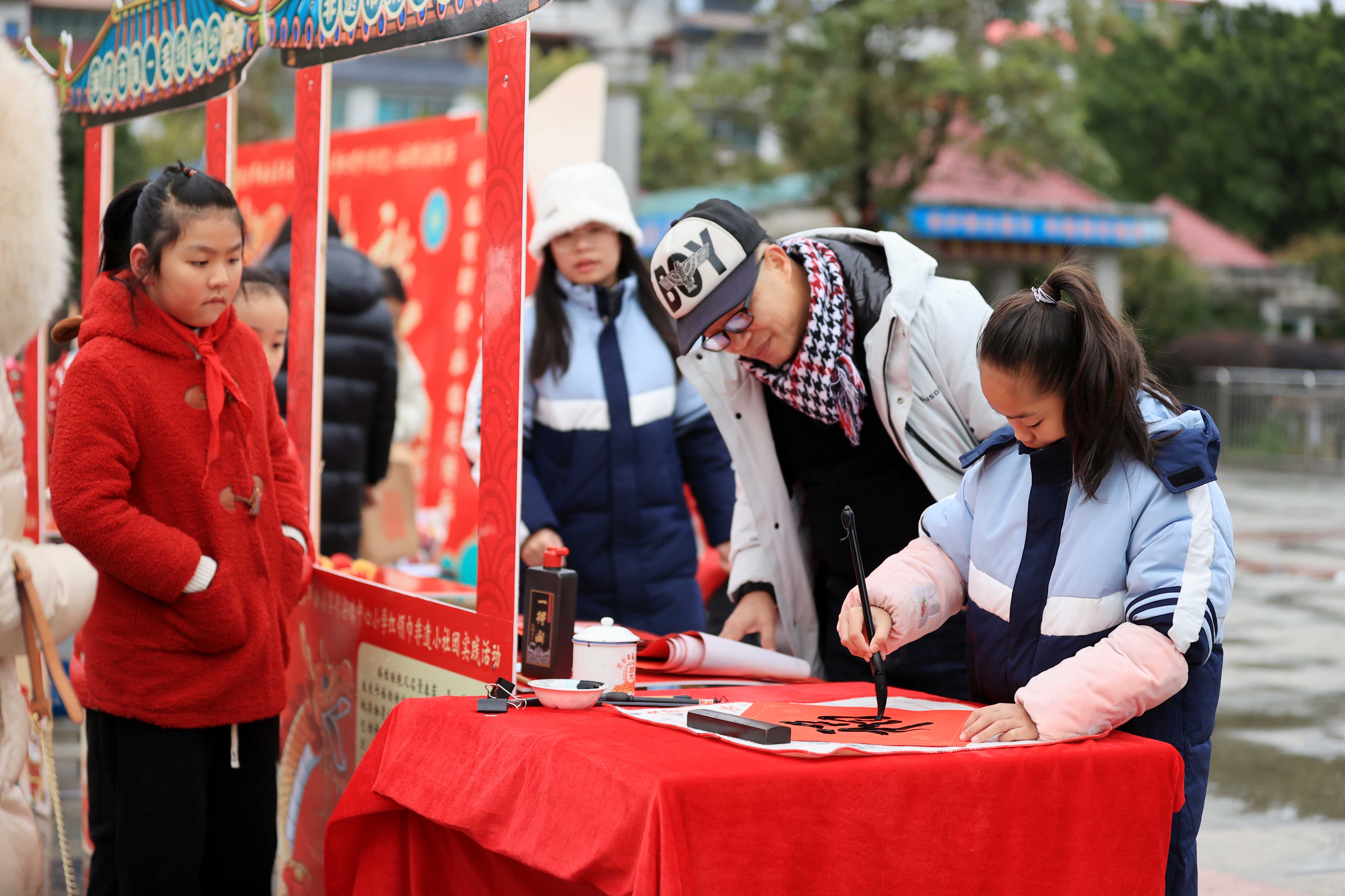 圖10：1月20日，在廣西柳州市融安縣長安廣場，一名小學生在書寫福字，準備贈送市民。（譚凱興 攝）.JPG