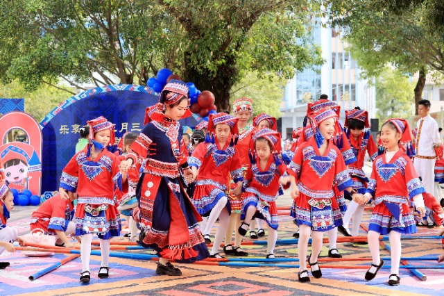 圖4：4月9日，在廣西柳州市融安縣實驗小學校園，一名老師帶著學生跳竹竿舞。（譚凱興 攝）.JPG