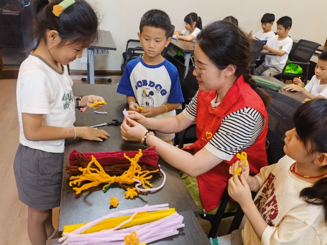 7月12日，在泰州市海陵區(qū)城東街道林湖社區(qū)，泰州市大浦小學“綠葉”暑期公益班的老師正在教孩子們一起做手工2（拍攝者：泰州市大浦中心小學  陳惠婷）.jpg